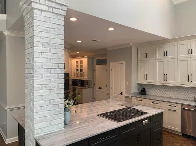 Interior painting by B Quality Painting LLC in Arlington, Tennessee. The image shows a white brick column, white cabinets, and a dark kitchen island.