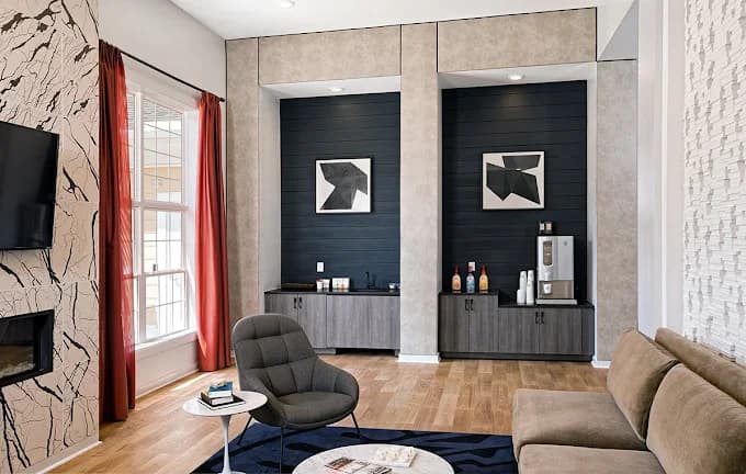 Interior painting project by Matrix Painting Inc. in Raleigh, NC. The image shows a room with dark walls, a fireplace, chairs, and tall windows.