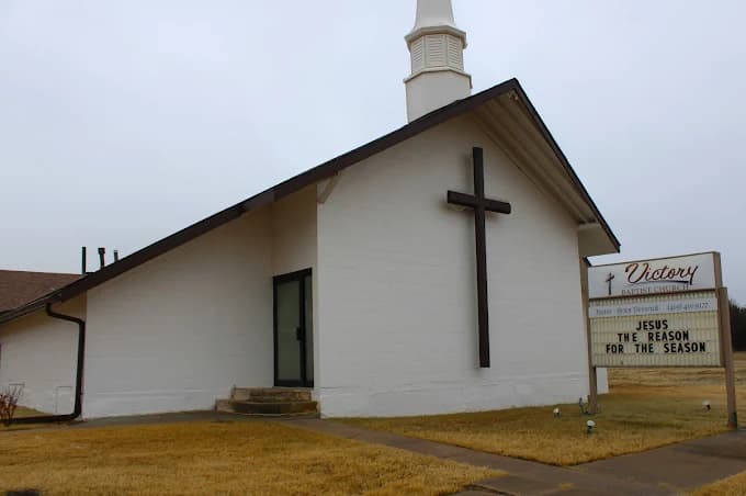 This is an image from Hometown Painting, located in Oklahoma. The photo shows a freshly painted white church exterior with a dark cross accent and a signboard in front of the building.