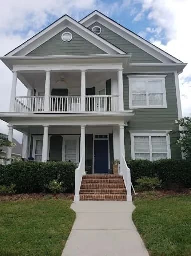 Randy Wilson Painting painting project in Chattanooga, Tennessee. The image shows a gray two-story home with white porch trim.