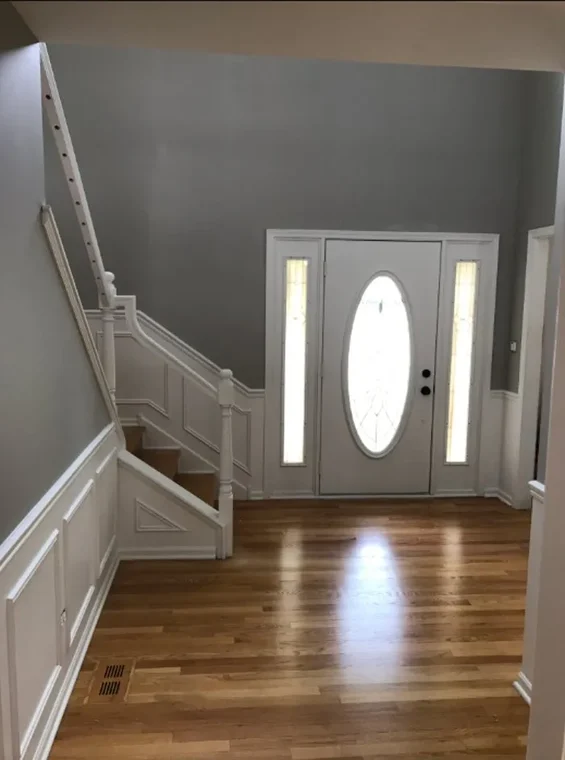 The entryway of a home featuring newly painted gray walls with crisp white trim, showcasing Jordan's Painting LLC’s attention to detail.