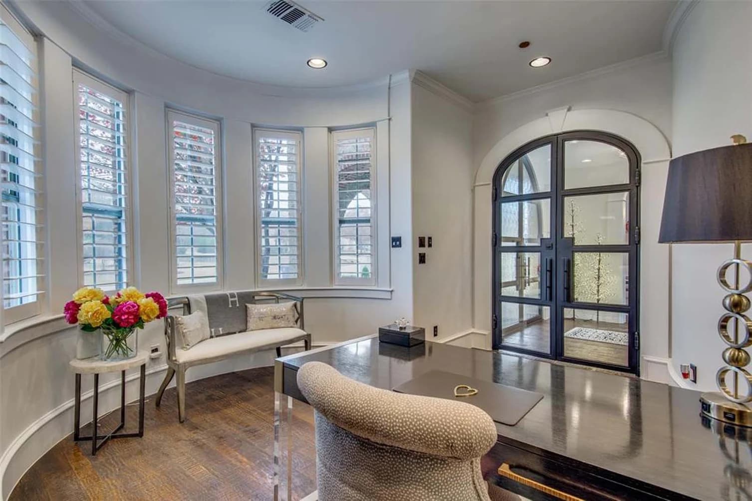This is an image from Fresh Coat Painters of Wichita.The image shows an elegant interior space with freshly painted white walls, updated trim, and black-framed double doors that create a clean and sophisticated finish.