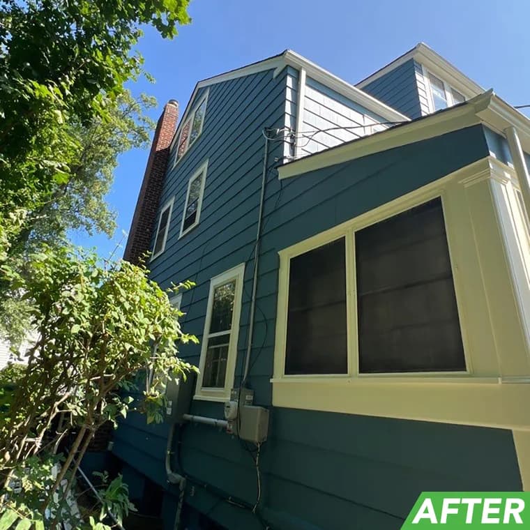 Freshly painted blue home exterior with cream-colored trim around windows and a sunroom, completed by Elite Painting and Power Washing, Inc.