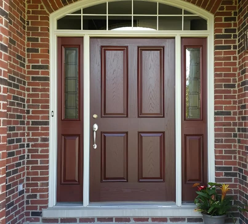Door painting by CertaPro Painters of Plainfield in Plainfield, Illinois. The image shows a brown front door with white trim and brick walls.
