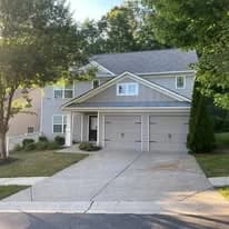 This is an image from Northeast Pro Painting & Restoration, located in New York. The image shows a light gray two-story suburban home with a freshly painted exterior, including the siding, garage doors, and trim.