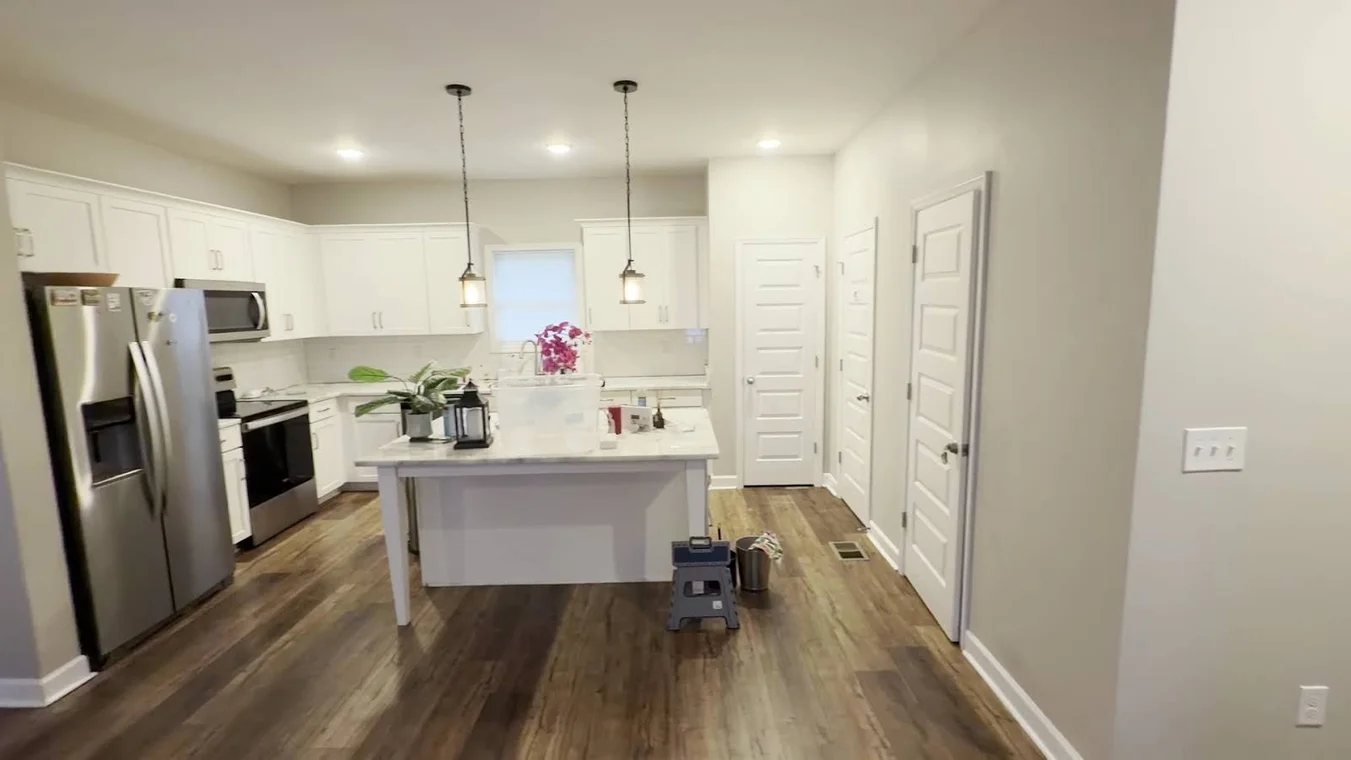 Covenant Painting Services painting project in Gallatin, Tennessee. The image shows a white kitchen with an island and stainless refrigerator.