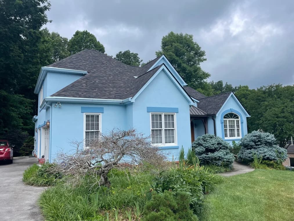 This is an image from That 1 Painter Knoxville, located in Tennessee. The image is a bright blue exterior home with dark roof and white trim repainted by That 1 Painter Knoxville.