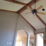 This is an image from West & Co Painting, LLC. The image shows an interior room with vaulted ceilings, exposed wood beams, and a ceiling fan.
