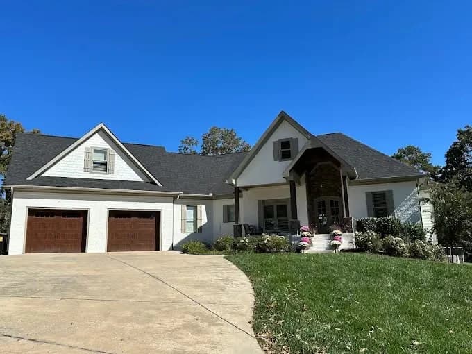 Randy Wilson Painting painting project in Chattanooga, Tennessee. The image shows a large white home with dark garage doors.