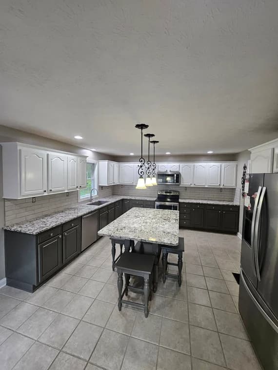 This is an image from Abell Painting LLC, located in Kentucky. The photo displays a spacious modern kitchen with white upper cabinets, dark lower cabinets, granite countertops, and tile flooring.