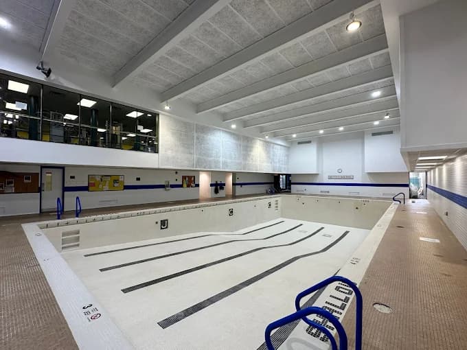 This is an image from JT’s Painting 518 LLC, located in New York. The image shows a commercial indoor swimming pool facility with freshly painted walls, ceilings, and clearly marked pool lanes.