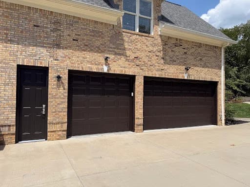 Painting work by Mike’s Painting in Oak Ridge, Tennessee. The image shows brown garage doors on a light home exterior.