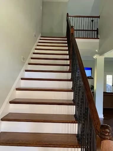Painting work by Pilgrim Painting in Knoxville, Tennessee. The image shows a white-and-brown staircase with dark railings.