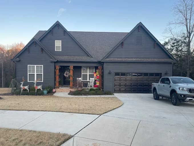 Exterior painting project by 360° Painting of Lake Norman in Charlotte, NC. The image shows a dark gray home with white shutters and a front porch.