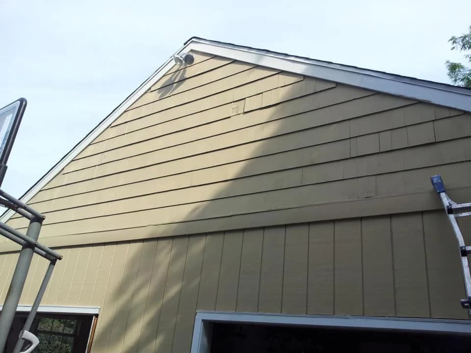 This is an image from Disbrow Painting And Handyman Services Company company, located in Levittown, PA. The image is an exterior siding and gable of a house undergoing painting preparation.