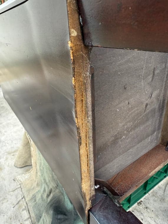 Close-up highlighting the poor condition of the vanity's wood finish