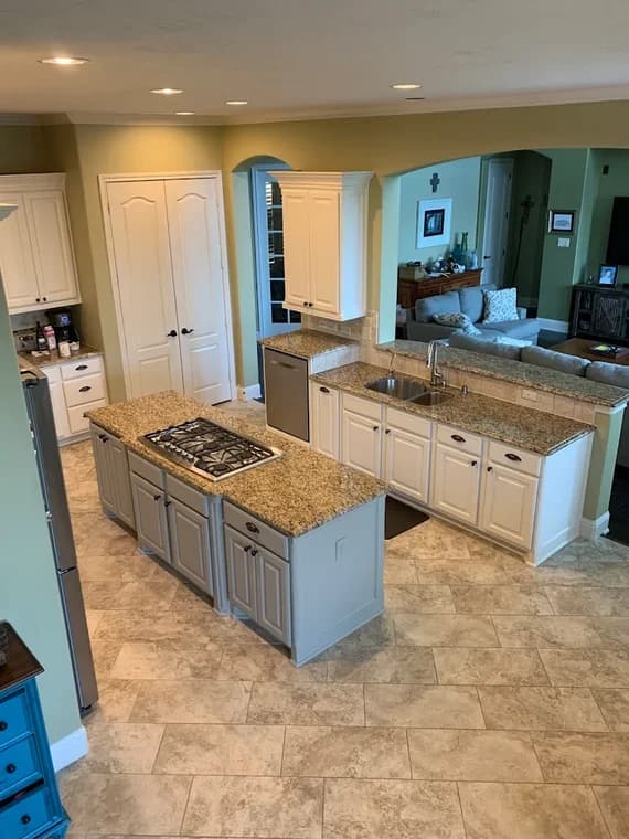 "This is an image from Lee House Paint & Repair, located in Texas. The kitchen includes two-tone cabinetry, granite countertops, and an open-concept view into the living area."
