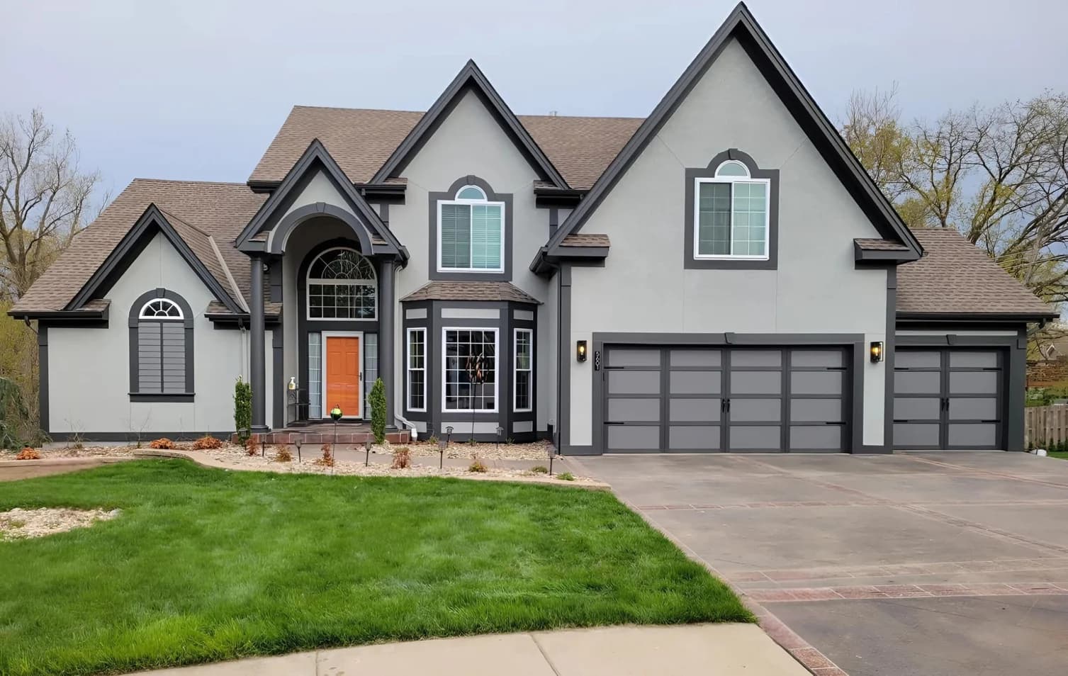This is an image from Neighborhood Painting and Restoration. The image is large gray home in Kansas City KS with bold trim and updated exterior painting