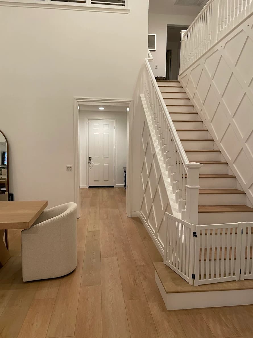 This is an image from ALLBRiGHT Painting, located in California. The image is from ALLBRiGHT Painting and shows interior painting featuring a white staircase with decorative wall paneling and light wood flooring.