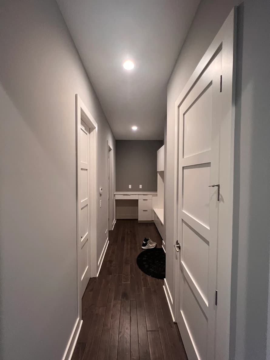 This is an image from PEMCO Painting Interior & Exterior Painter Overland Park. The image is an interior hallway in Overland Park KS with smooth gray walls, bright white trim, and recessed ceiling lighting.