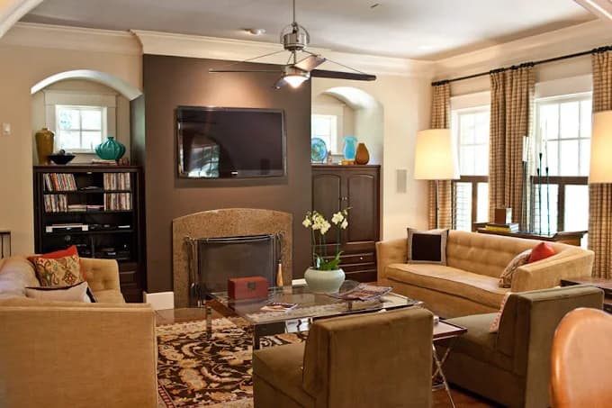 This is an image from Whitehouse Residential & Commercial Painting, located in Kentucky. The image shows a professionally painted living room interior with neutral wall colors, a fireplace accent wall, ceiling fan, and coordinated furnishings.