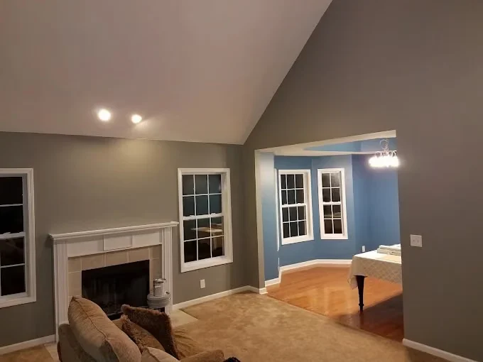 Painting project by Fresh Coat Painters of Clarksville in Clarksville, Tennessee. The image shows a gray living room with a white fireplace.