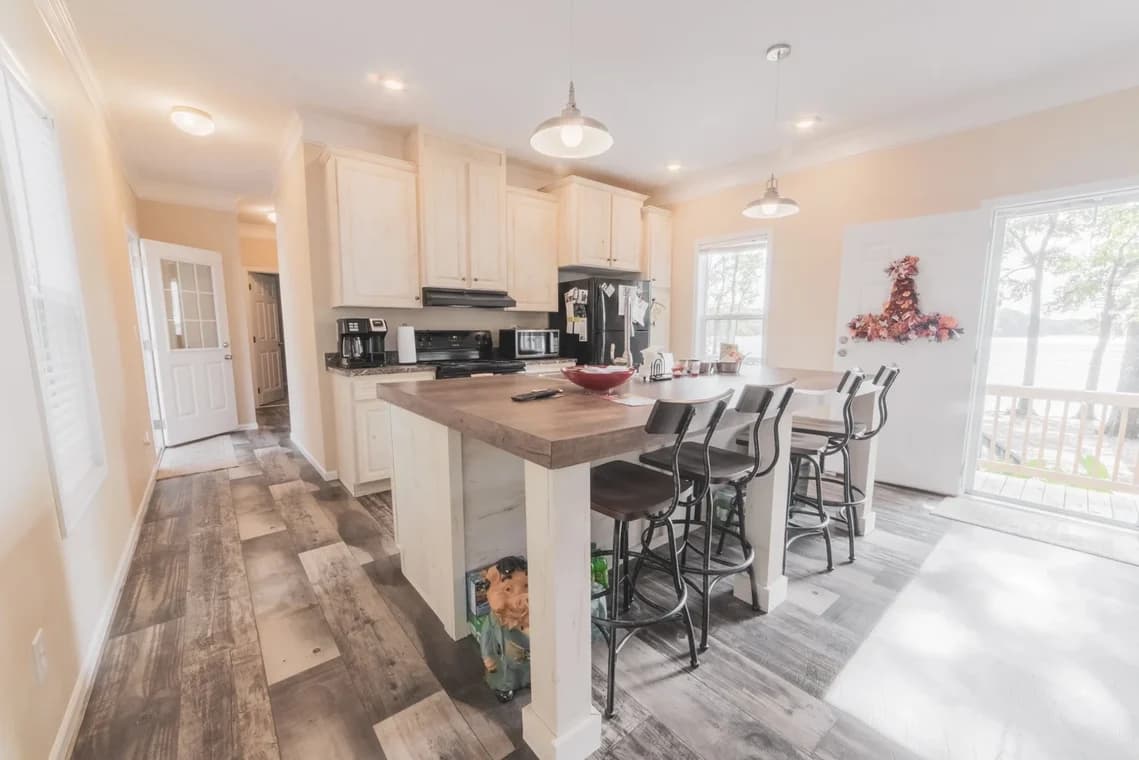 Interior painting project by Richard's Painting of Lexington, NC in Salisbury, NC. The image shows a bright kitchen with white cabinets, island, and window.