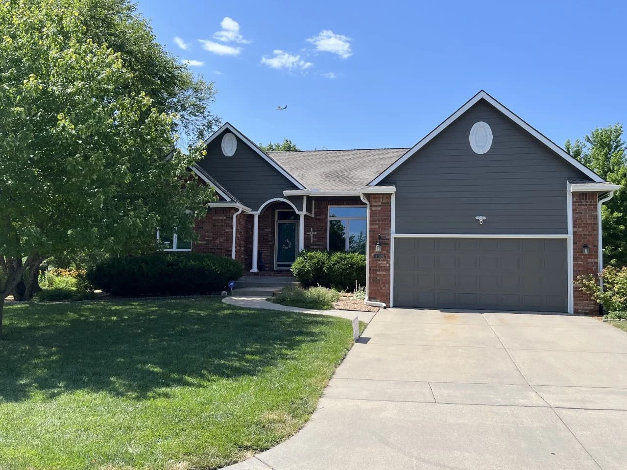 This is an image from CertaPro Painters of Wichita East KS. The image shows a freshly painted gray single-story home with crisp white trim, updated garage door color, and clean siding that gives the exterior a polished, modern appearance.