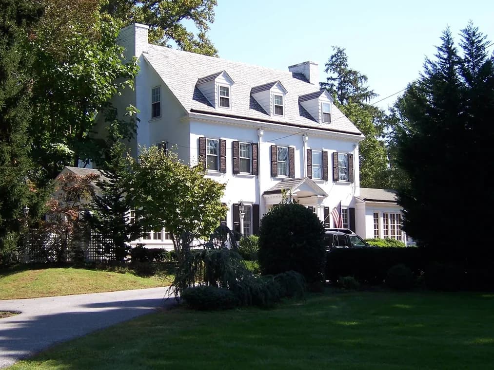 This is an image from Cherry Hill Painting in New Jersey. It shows a Tudor-style house with a combination of brick and painted paneling, emphasizing craftsmanship and detail.