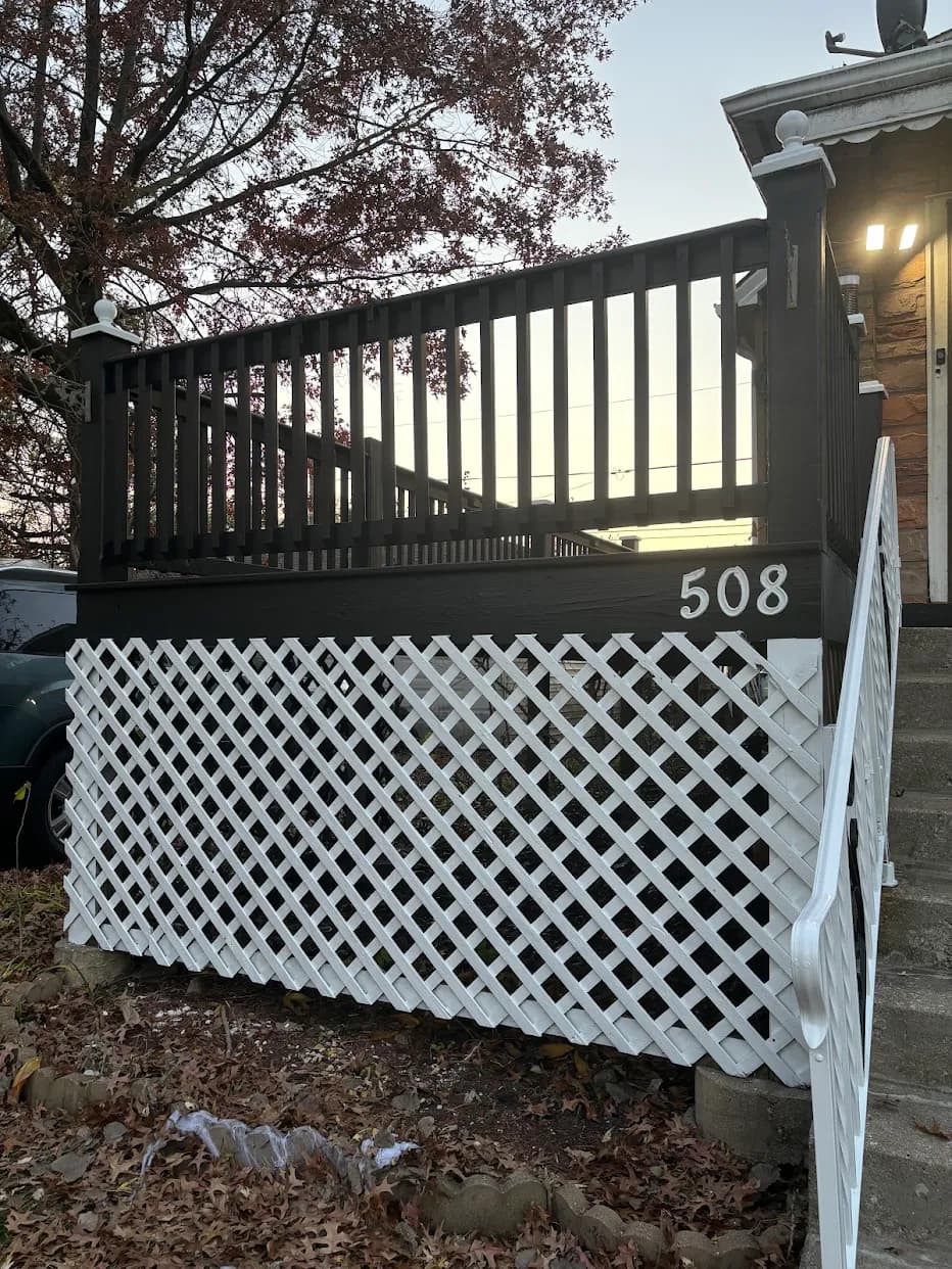 Exterior painting project by JVC Painting in Oak Lawn, Illinois. The image shows a front porch with dark railings, white lattice, white stair rails, and house numbers.