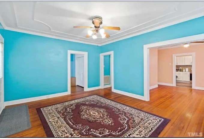 Interior painting project by Dr. Lopez Painting LLC in Durham, NC. The image shows turquoise walls, white trim, wood floor, and a patterned rug.