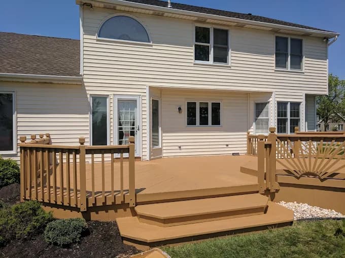 This is an image from Painting by Robertson, located in California. The image shows a freshly painted backyard deck with tan decking boards, matching railings, and clean trim against a white home exterior.