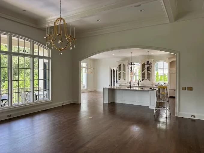 Painting project by New Direction Painting in Franklin, Tennessee. The image shows a neutral open living and dining room.