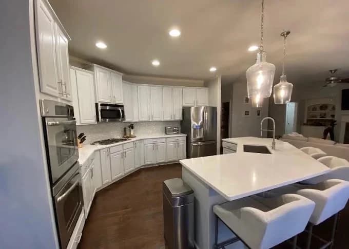 Painting work by Nashville Painting Company - Brentwood in Brentwood, Tennessee. The image shows a white kitchen with a large island.