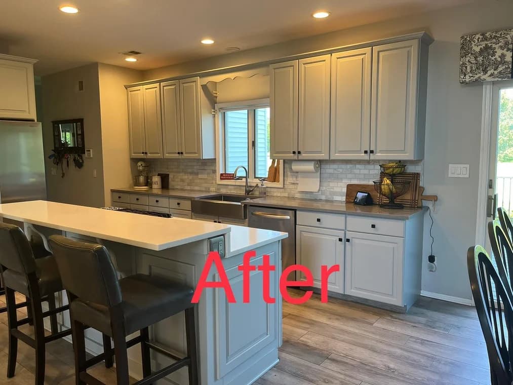 Modern kitchen with freshly painted cabinets in soft beige, complemented by a white countertop and tiled backsplash.
