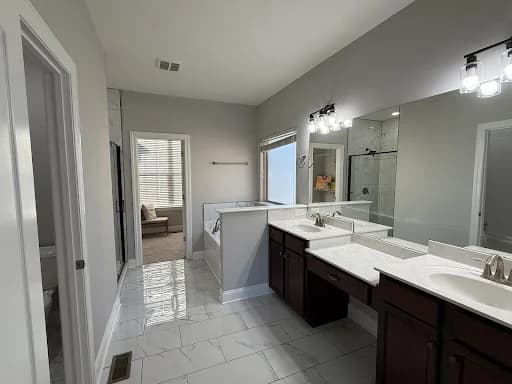 Painting project by Premier Painting Company in Smyrna, Tennessee. The image shows a gray bathroom with a white vanity.