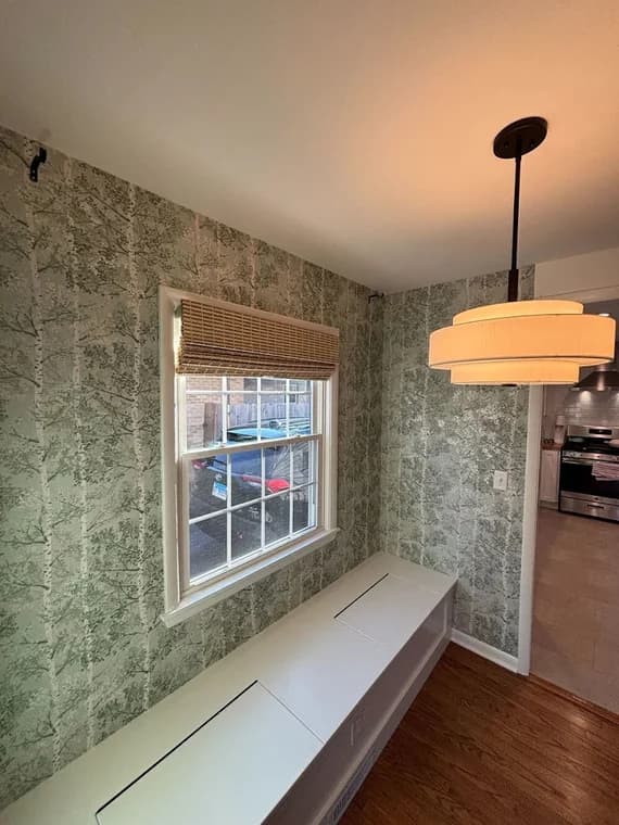 Wallpaper installation by D'franco Painting & Wallpaper in Huntley, Illinois. The image shows green patterned wallpaper, white trim, and a window bench.