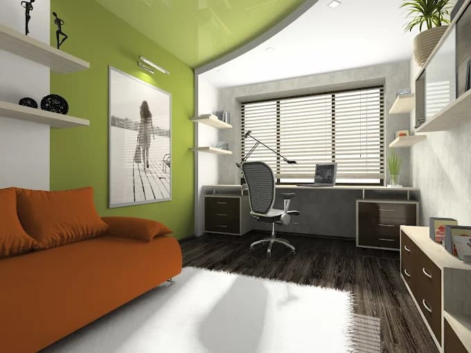 This is an image from Oliveira Painting Inc., located in Massachusetts. The photo shows a modern home office with a bold green accent wall, sleek dark wood flooring, and contemporary furniture including an orange sofa and a desk by the window.