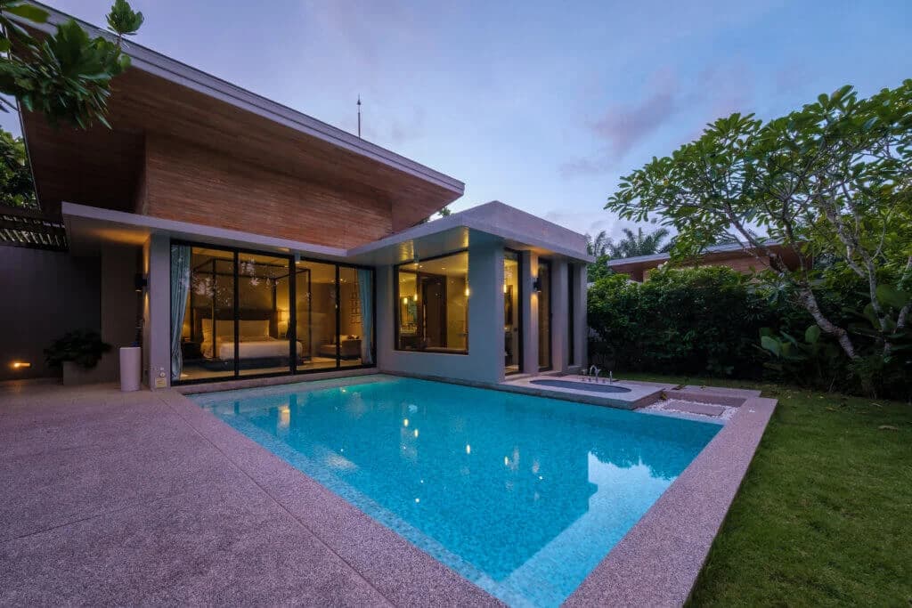 "This is an image from Lee House Paint & Repair, located in Texas. The exterior photo shows a modern home with large glass windows opening to a backyard pool at dusk."