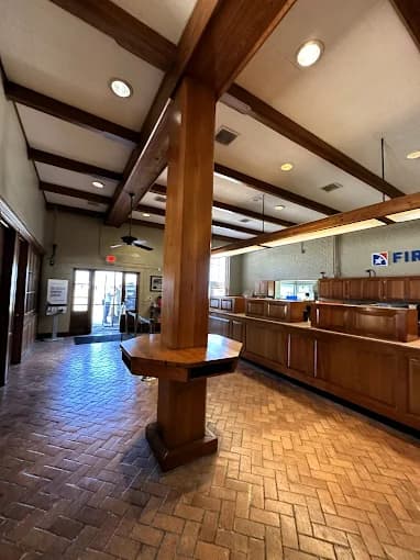 This is an image from Ozuna’s Painting Inc., located in Louisiana. The photo shows a commercial interior with polished wooden beams, matching wood cabinetry, and brick-patterned flooring, highlighting the company’s professional interior painting and finishing services for business spaces.