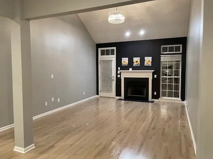 Painting work by Nashville Painting Company - Brentwood in Brentwood, Tennessee. The image shows a gray living room with a black fireplace.