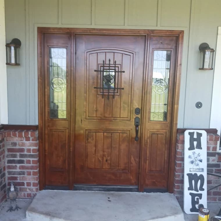 Front entry door refinished by Remarkable Painting, highlighting a wooden door with decorative glass panels and a rich, stained finish that enhances its natural wood grain.