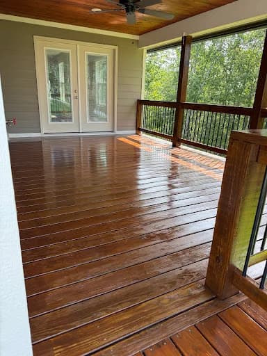 Painting work by Mike’s Painting in Oak Ridge, Tennessee. The image shows a stained screened deck with wood railings.