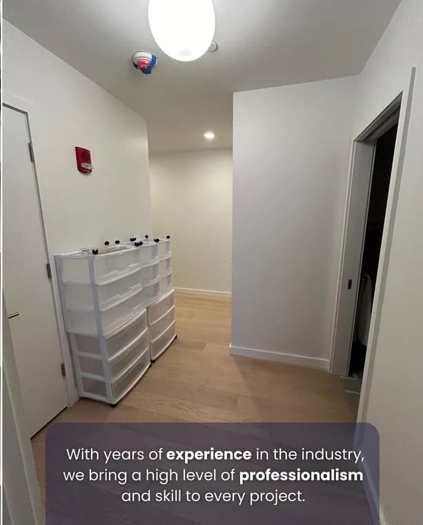 This is an image from Suetam Painting & Finishes. It shows a freshly painted hallway with clean white walls and a light wood floor, emphasizing the company’s professional finish and attention to detail.