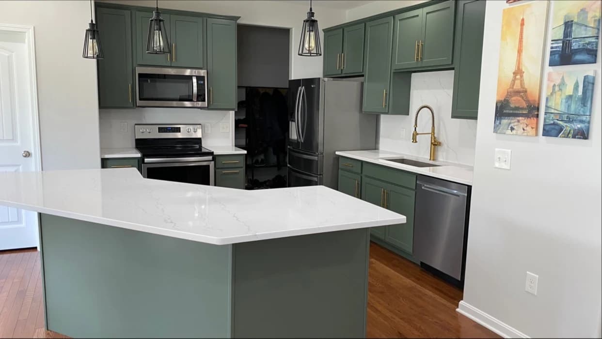Cabinet painting by Joyful Cabinet Painting in Cincinnati, Ohio. The image shows gray cabinets and a white island counter.