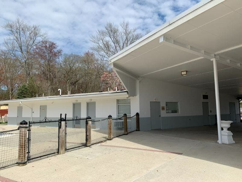 Commercial building with flat roofing and clean white-and-gray walls freshly painted by Touch of the Brush Painting.