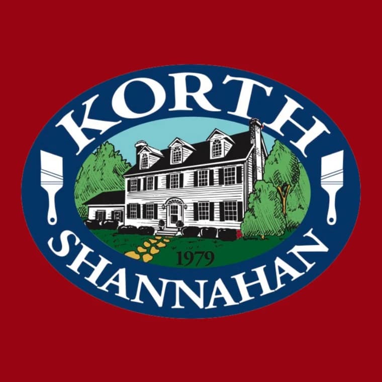 This is an image from Korth & Shannahan Painting and Carpentry, located in New York. The logo for Korth & Shannahan Painting and Carpentry features an illustrated colonial-style home with two paintbrushes and the business name in a blue oval.