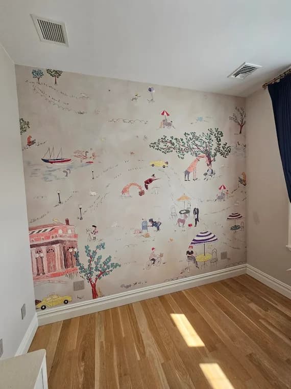 This is an image from Interior Finishing NYC, located in New York. The mural wall displays whimsical illustrated scenes including trees, people, and buildings, adding a playful design element to the bright roomhttps://imagedelivery.net/6JkaVsfAvbV7M0nIAmm2-g/fa439e11-c74b-4c97-988c-9ade30c34b00/public