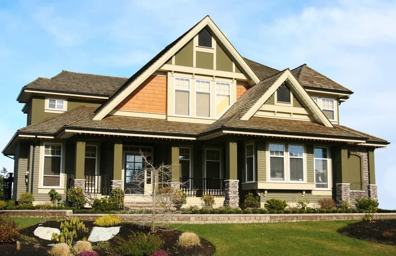 This is an image from CertaPro Painters of San Antonio, located in Texas. The picture shows a two-story craftsman-style home with olive green siding, tan trim, and stone column bases.