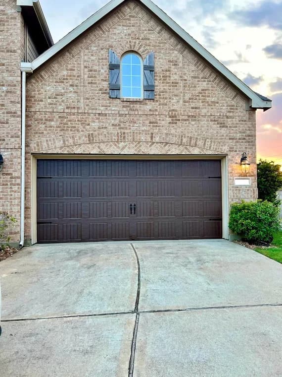 "This is an image from Perera Painting & Remodeling, located in Texas. The photo shows a freshly painted brick home exterior with a dark brown garage door and clean driveway."